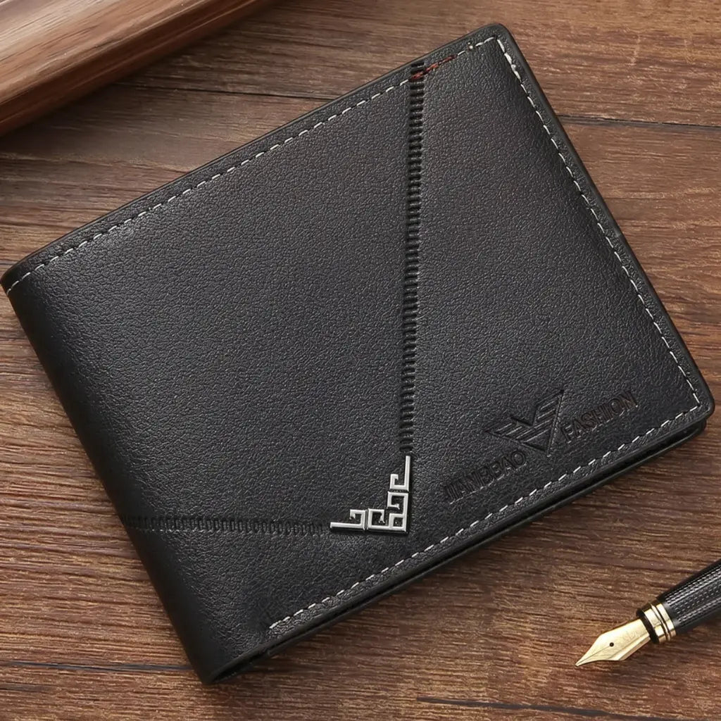  Angled front view of the Arlen slim black wallet on a wooden desk with a fountain pen, emphasizing the decorative diagonal stitching and the silver metallic corner detail.