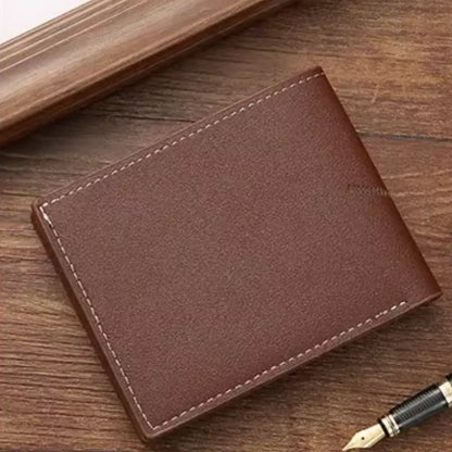 Back view of the brown slim wallet on a wooden surface, with a pen nearby.