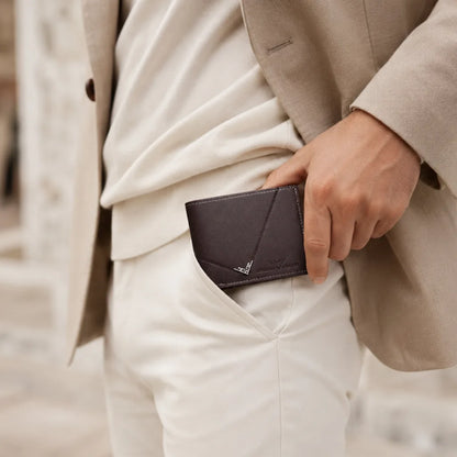 Man placing the Wallet for Men Slim Model Arlen Coffee by CORVIKO into a trouser pocket in a refined everyday outfit